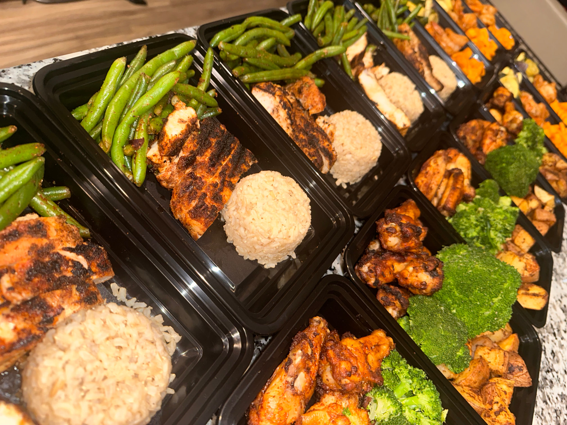 Rows of prepared E's Healthy Eats meals with chicken, rice and vegetables