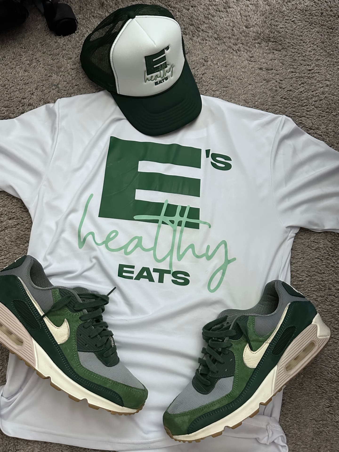 E's Healthy Eats tee, trucker hat and sneakers laid out together