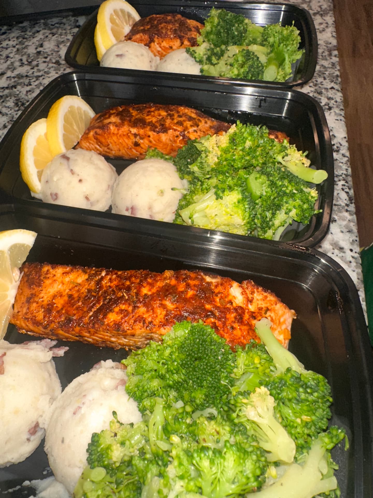 Prepared salmon, mashed potatoes and broccoli in weekly meal prep containers